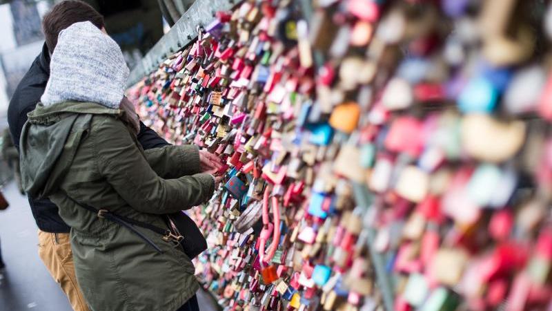 Alles für die Liebe: Pietro Lombardi überrascht Paare aus Köln Paar befestigt ein Liebesschloss an einer Brücke