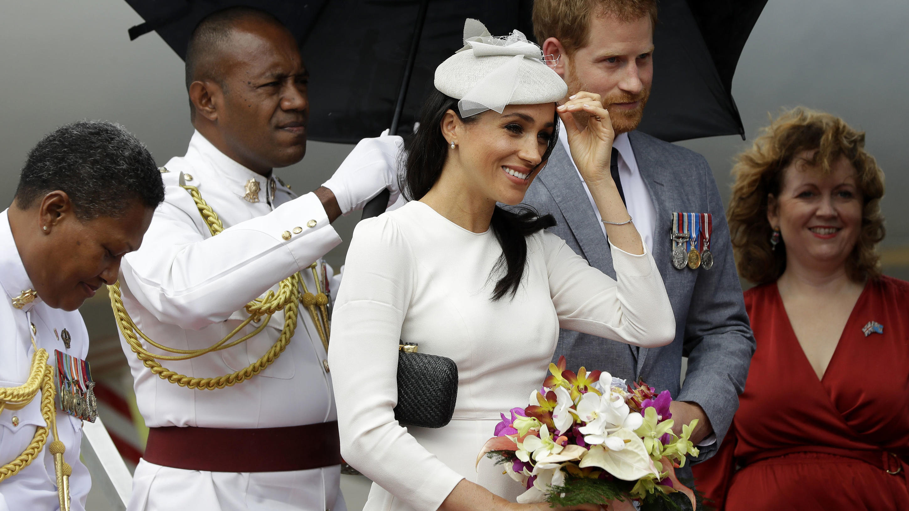 Prinz Harry und Herzogin Meghan werden auf den Fidschi Inseln euphorisch begrüßt 23.10.2018, Fidschi, Suva: Der britische Prinz Harry, Herzog von Sussex, und seine Frau Meghan (M), Herzogin von Sussex, nach ihrer Ankunft aus dem Flughafen. Foto: Kirsty Wigglesworth/Press Association/dpa +++ dpa-Bildfunk +++