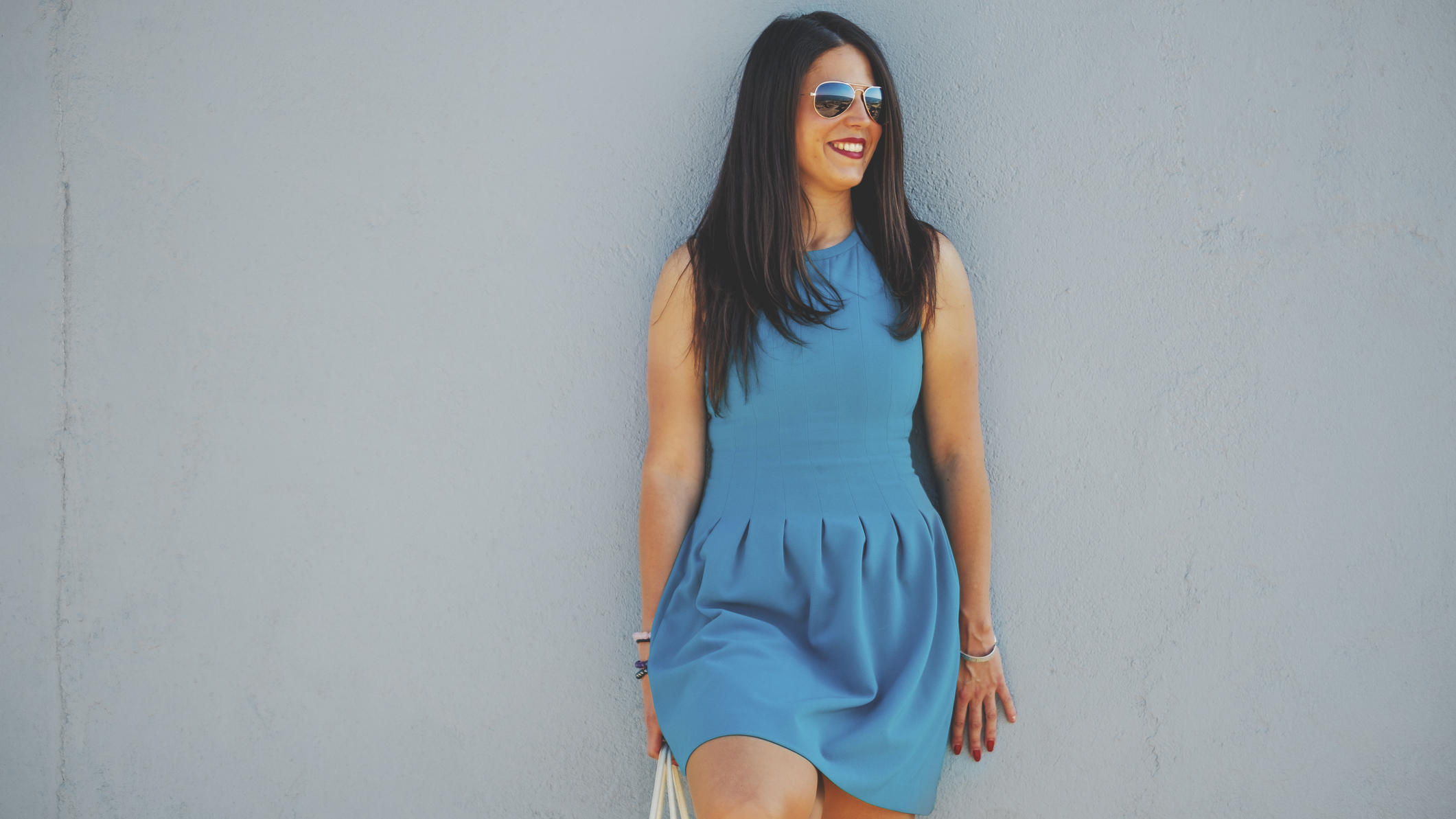 Diese 5 Farben lassen Ihre Haut brauner wirken Junge Frau mit blauem Kleid