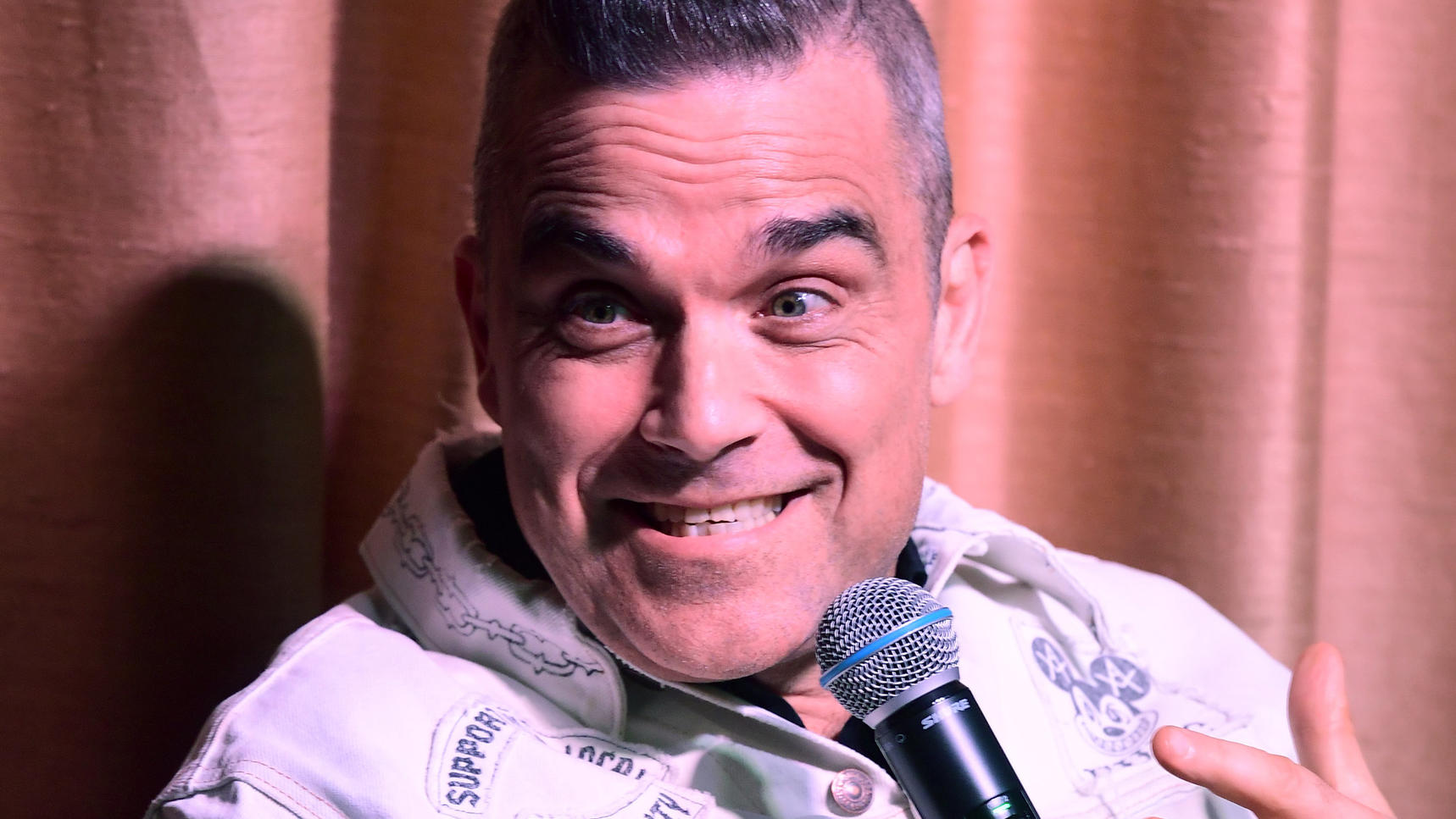 Robbie Williams gründet eine neue Band und eröffnet Club in Berlin ARCHIV - 13.06.2019, Großbritannien, London: Popstar Robbie Williams spricht auf einer Pressekonferenz mit dem X Factors LMA Chor im White City House. Er plant 25 Jahre nach seinem Ausstieg bei der legendären Boygroup Take That eine neue Band und auß