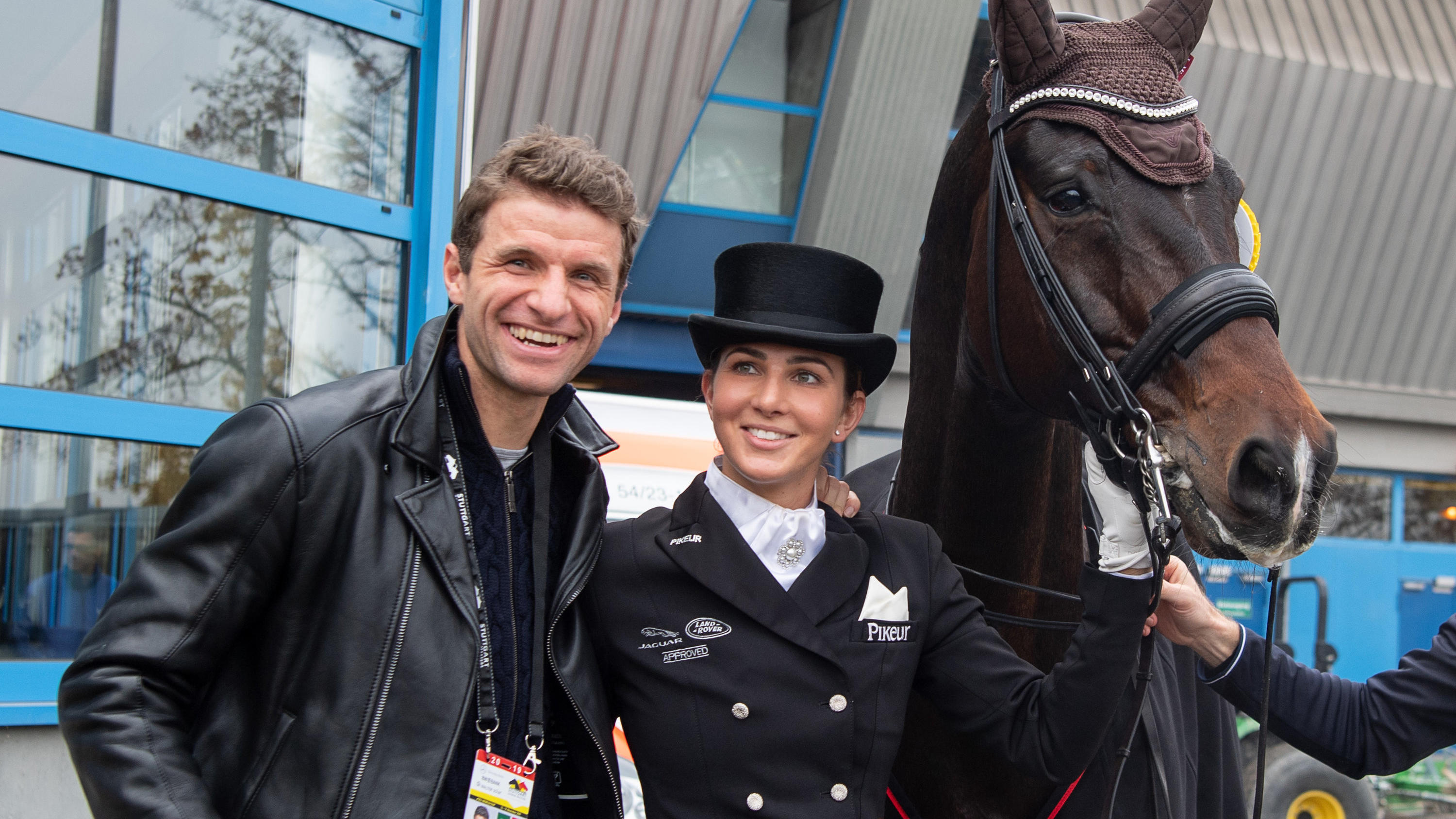 Frau Müller, Kimmich und Co.: Diese Ladies strahlen auch ganz ohne ihre Star-Partner ARCHIV - 16.11.2019, Baden-Württemberg, Stuttgart: Pferdesport, 35. Stuttgart German Masters, Dressur, Qualifikation zum Master: Dressurreiterin Lisa Müller steht zwischen ihrem Pferd Stand by me und ihrem Mann Thomas Müller, Fußballspieler des FC Ba