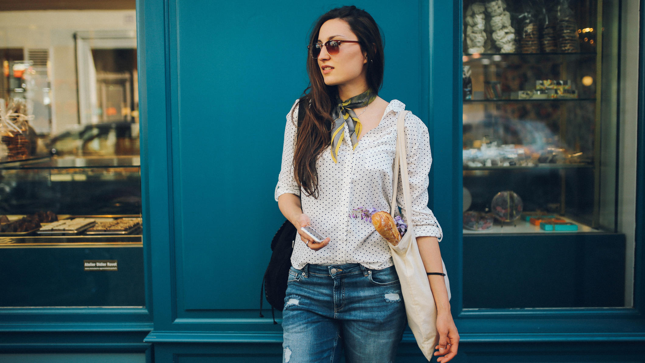 French Chic: Diese 5 Teile sehen wir im Frühling Frau steht vor einer Bäckerei in Paris.