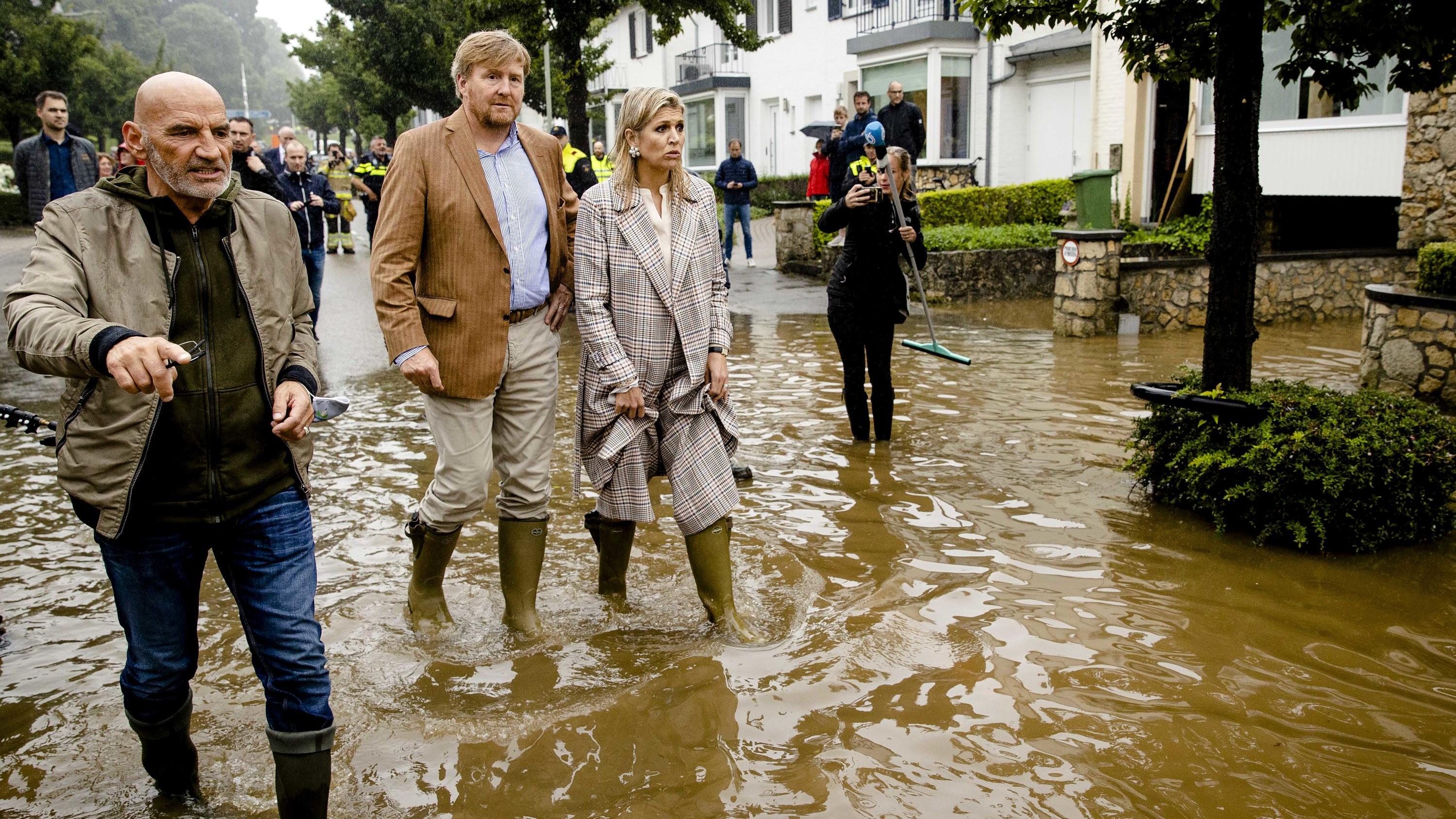 König Willem-Alexander & Königin Máxima waten in Gummistiefeln durch Valkenburg Willem-Alexander und Máxima wirken deutlich betroffen, als sie mit Gummistiefeln durch das knöchelhohe Wasser in Valkenburg waten.