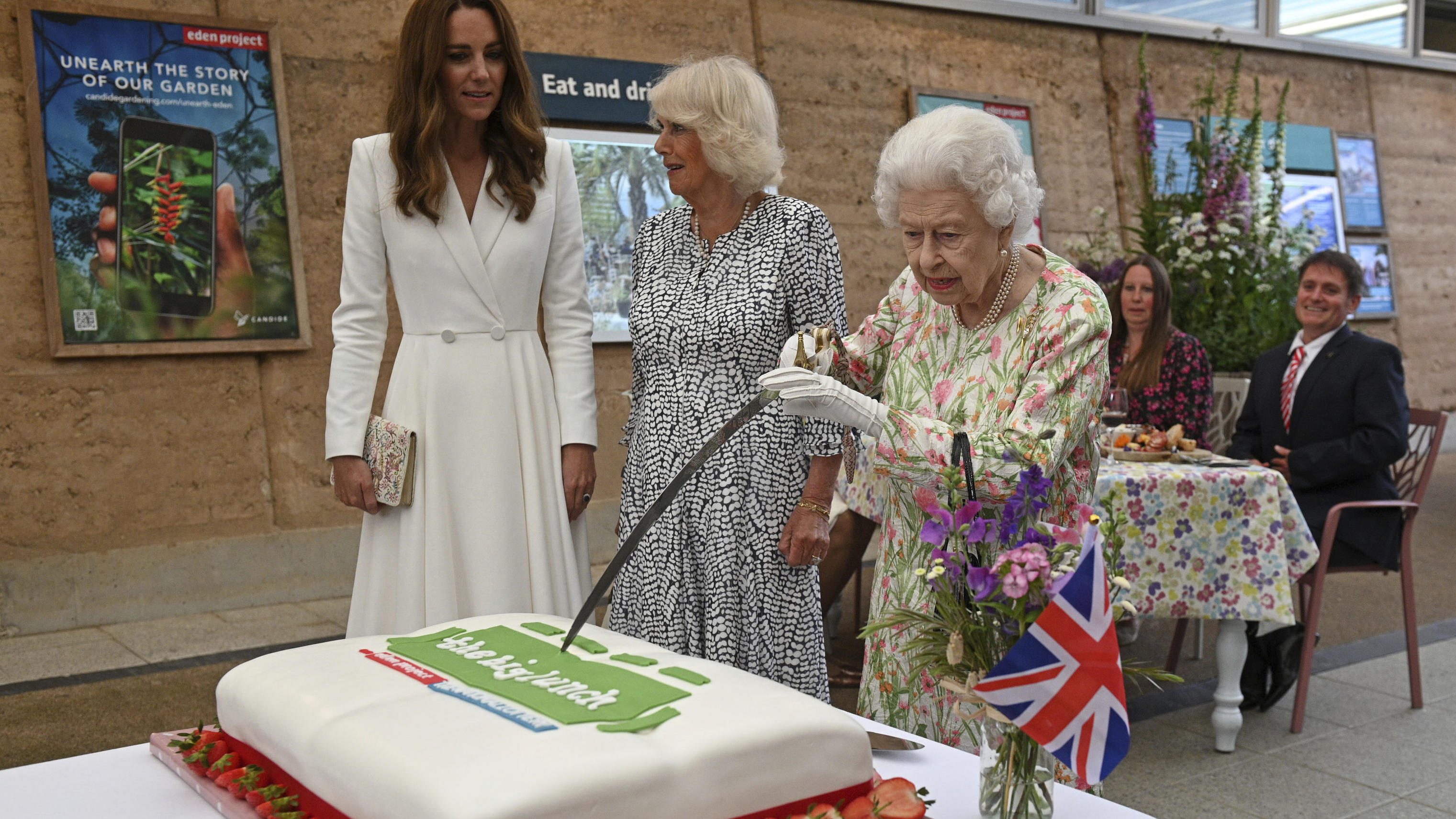 Royaler Speiseplan von Queen Elizabeth: DAS sind ihre Lieblingsspeisen Die Queen mag Torte! Hier schneidet sie, neben Camilla und Kate, einen Kuchen mit einem Schwert an. Juni, 2021.