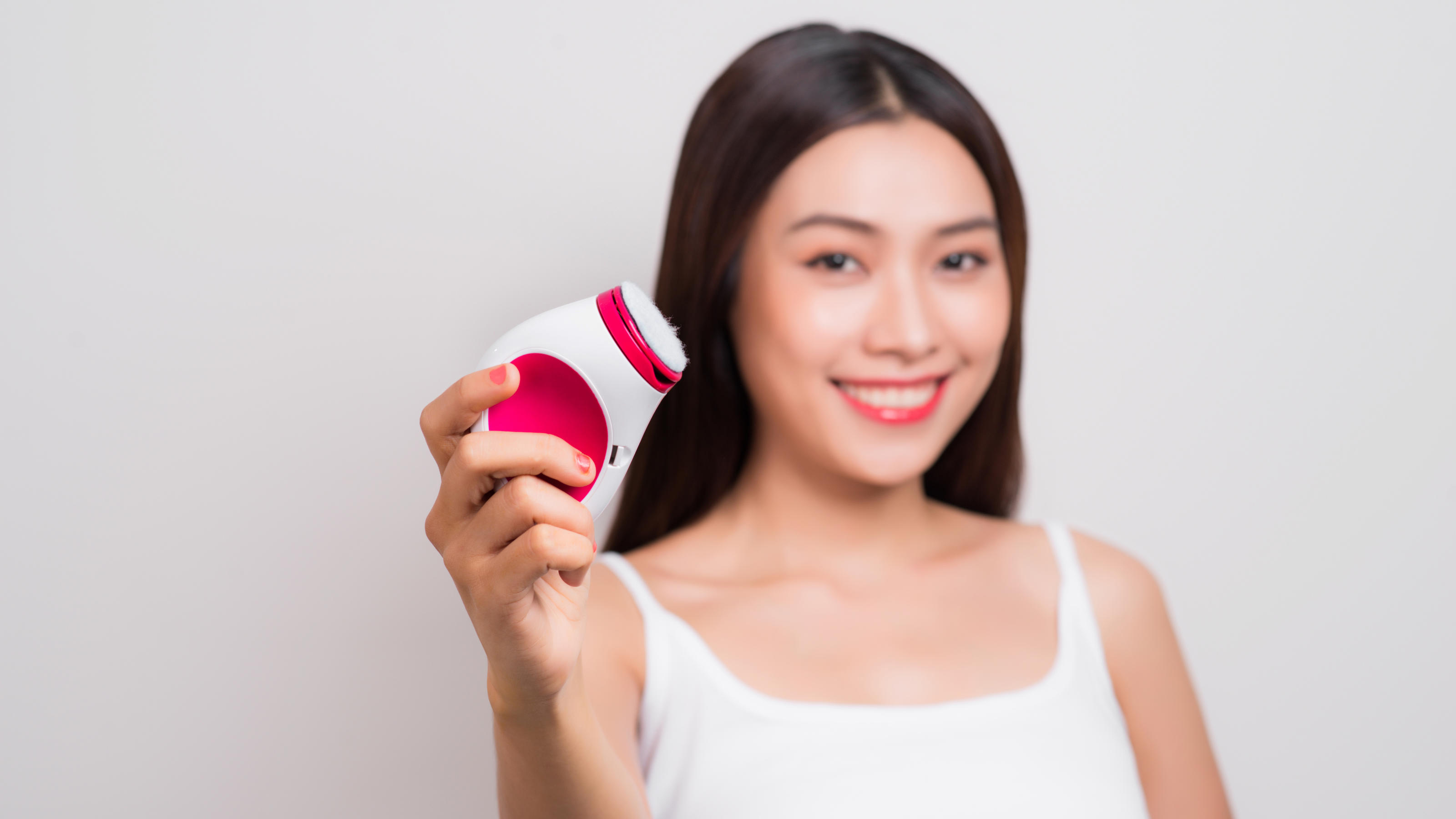 Top oder Flop? Diese Beauty-Gadgets kosten unter 50 Euro Frau mit elektrischer Gesichtsbürste.