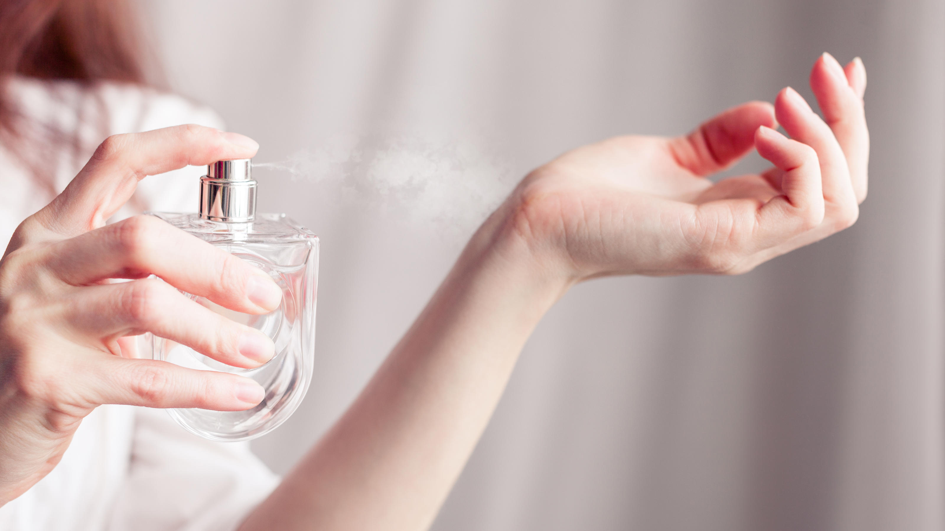 Parfum-Dupes: Diese Düfte riechen "echt" – sind aber viel günstiger! Frau, die Parfum auf ihren Arm sprüht.
