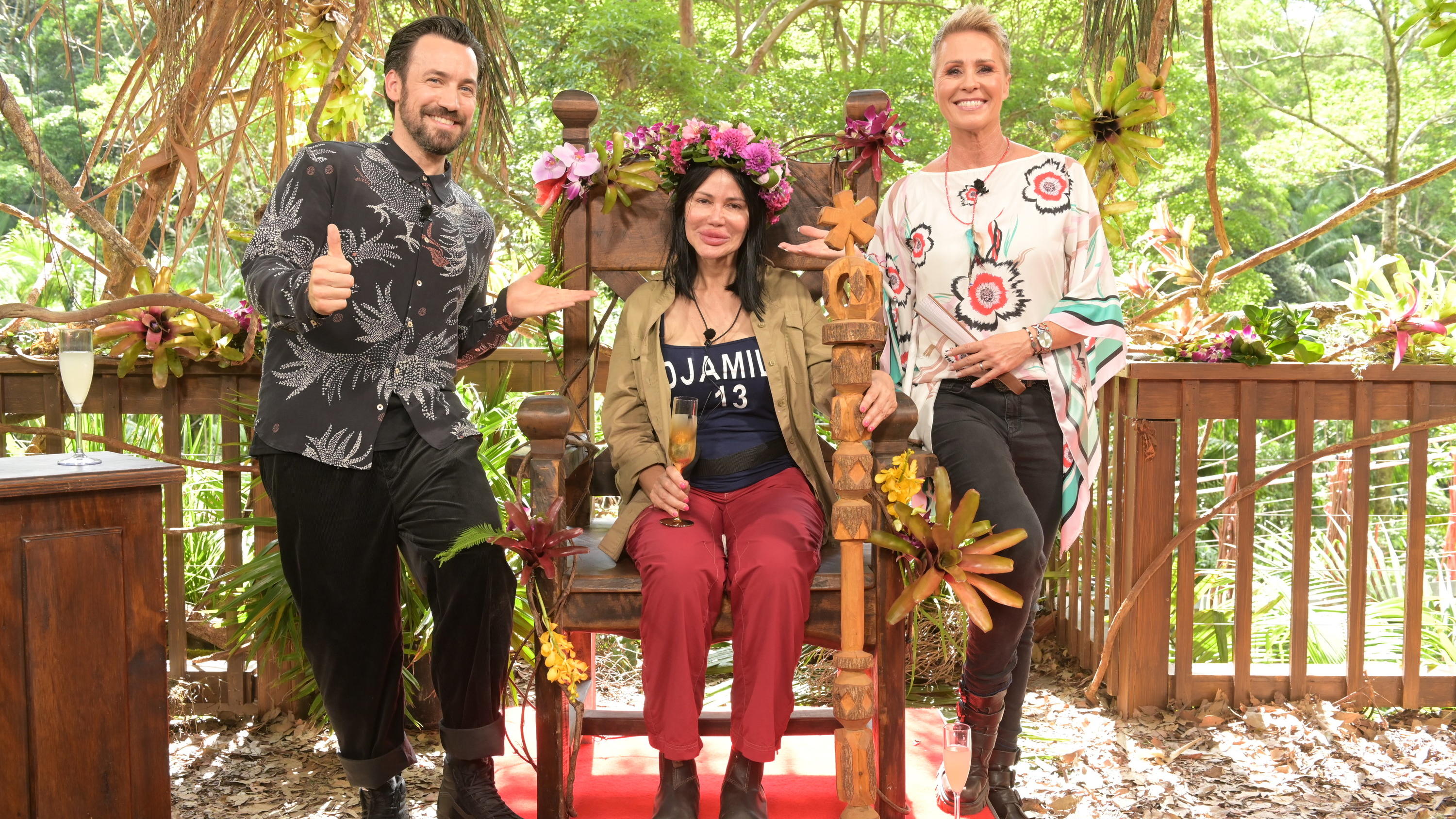 Darum hat "Queen D" Djamila Rowe die Herzen der Zuschauer erobert 30.01.2023, Australien, Brisbane: Visagistin Djamila Rowe sitzt mit ihrer Krone nach dem Sieg beim RTL-Dschungelcamp 2023 auf ihrem Thron neben der Moderatorin Sonja Zietlow (r) und Moderator Jan Köppen. Die Visagistin und Reality-TV-Kandidatin Djami
