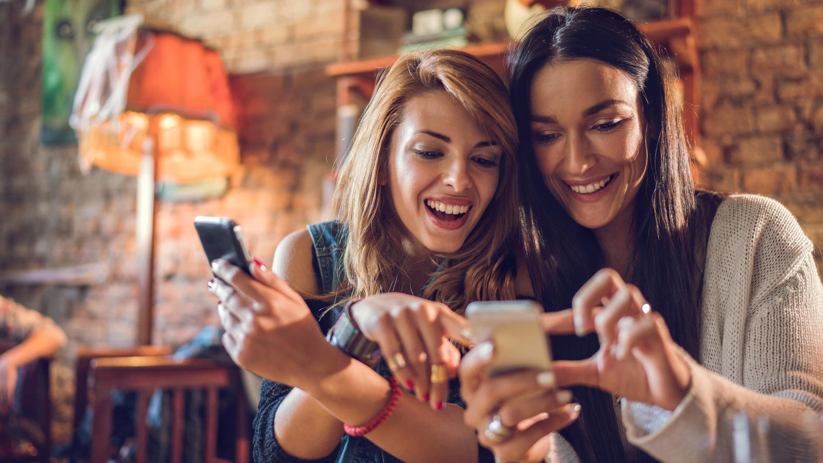Handyvertrag im Check: 6 GB für 6 Euro im Telekom-Netz Happy women using their mobile phones while relaxing in a cafe.