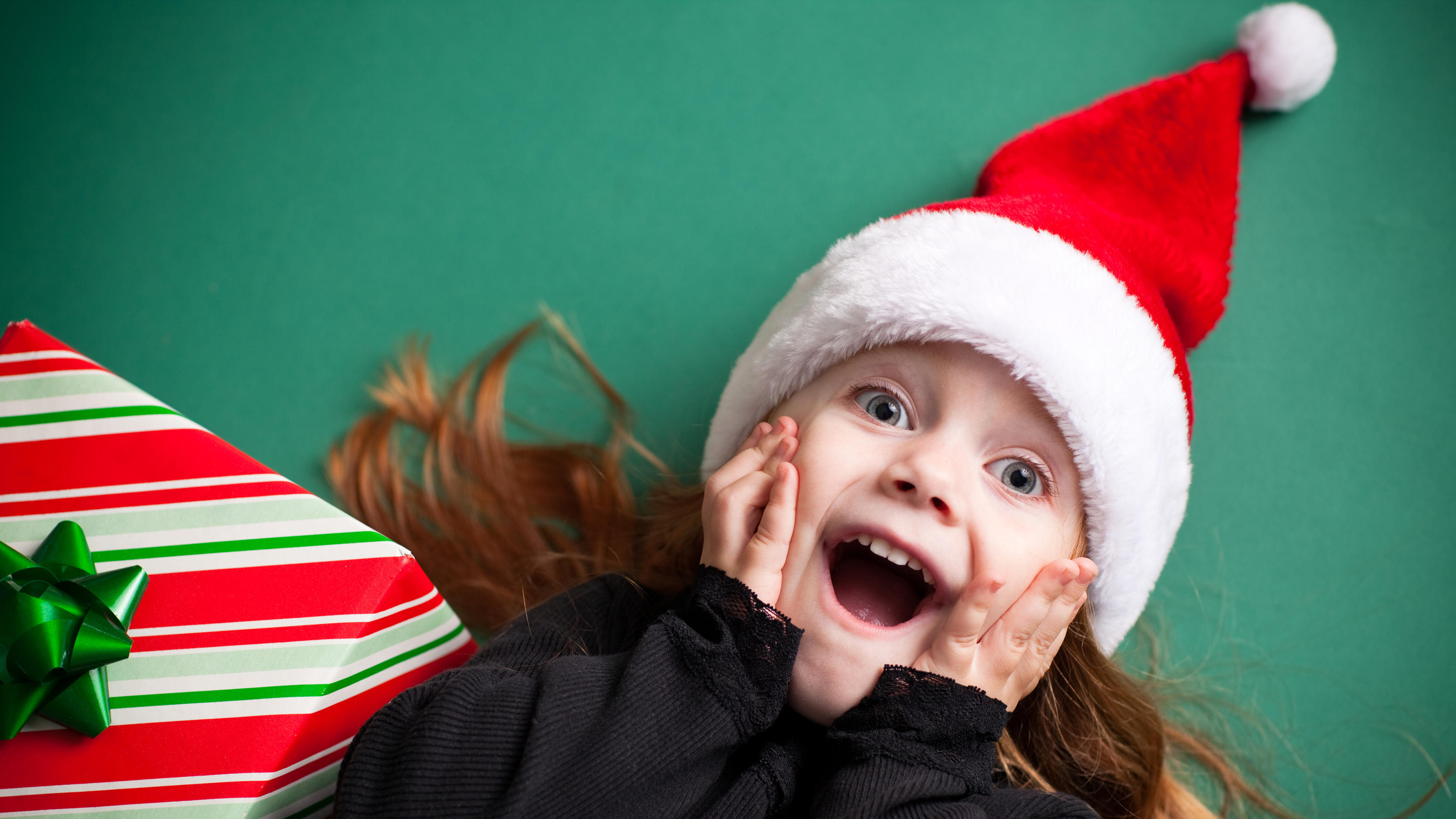 Grüner Hintergrund mit einem fröhlichen Mädchen an Weihnachten.