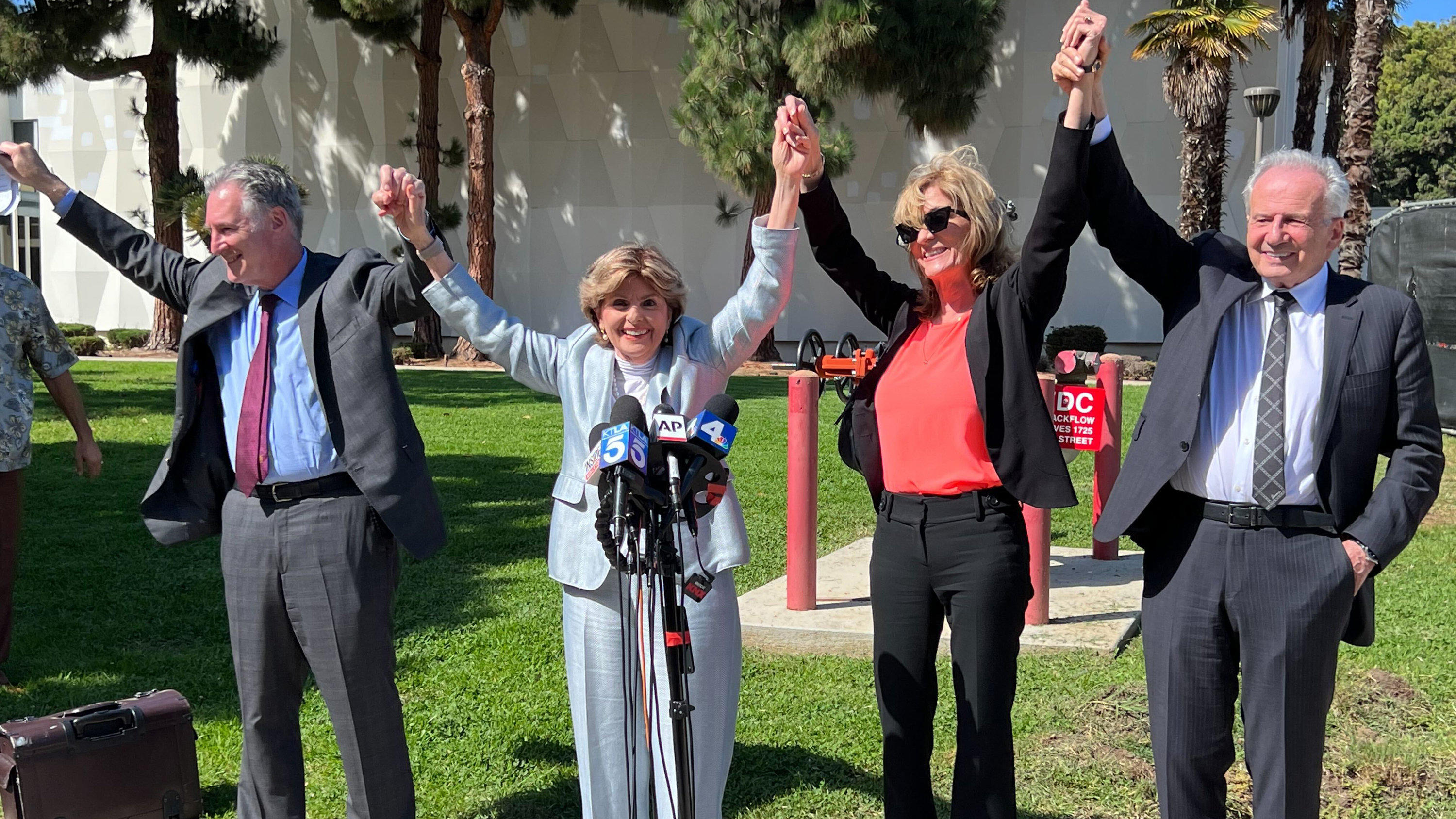 Attorneys John West, from left, Gloria Allred, plaintiff Judy Huth and attorney Nathan Goldberg join arms following a verdict in Huth's favor in a civil trial involving actor Bill Cosby outside the Santa Monica Courthouse on Tuesday, March 21, 2022. 