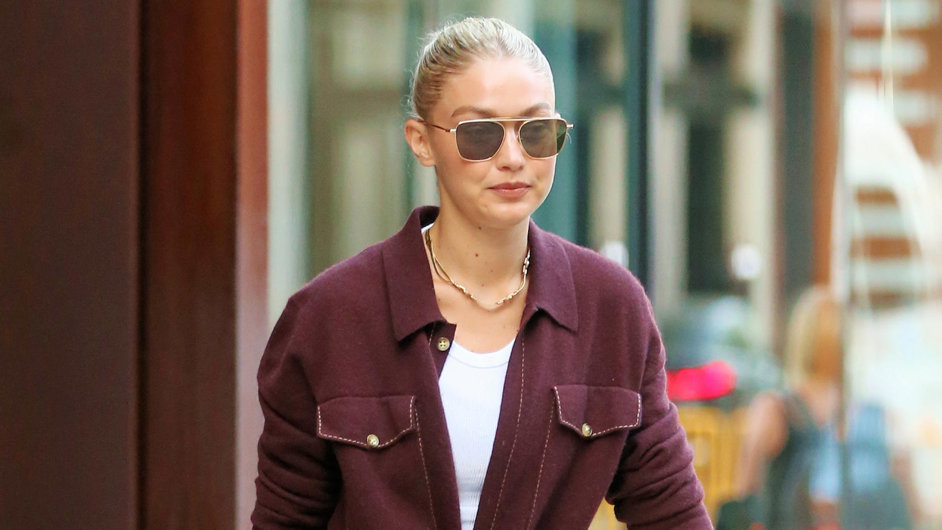 SONDERKONDITIONEN: MINDESTHONORAR: EXCLUSIVE: Gigi Hadid wears a maroon jumpsuit and carries a black leather overnight bag on her way to the airport in New York City. Gigi's driver wheeled her yellow-orange suitcase to the car.Pictured: Gigi HadidRef